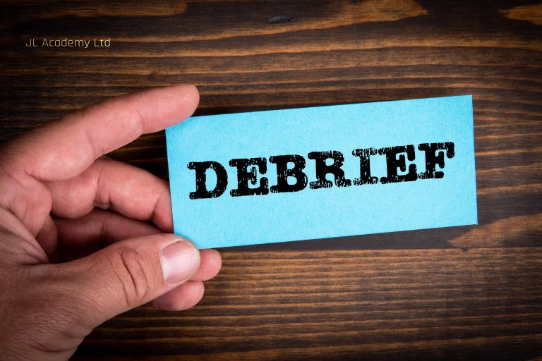 DEBRIEF concept Blue paper sheet with text in man's hands, wooden texture background